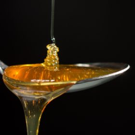 Miel liquide dans une cuillère : la fermentation du miel peut se produire dans le pot après récolte.