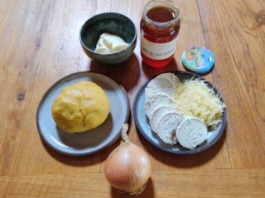 Ingrédients pour faire la tarte : oignon, pâte brisée, chèvre, fromage râpé, miel, crème fraîche.